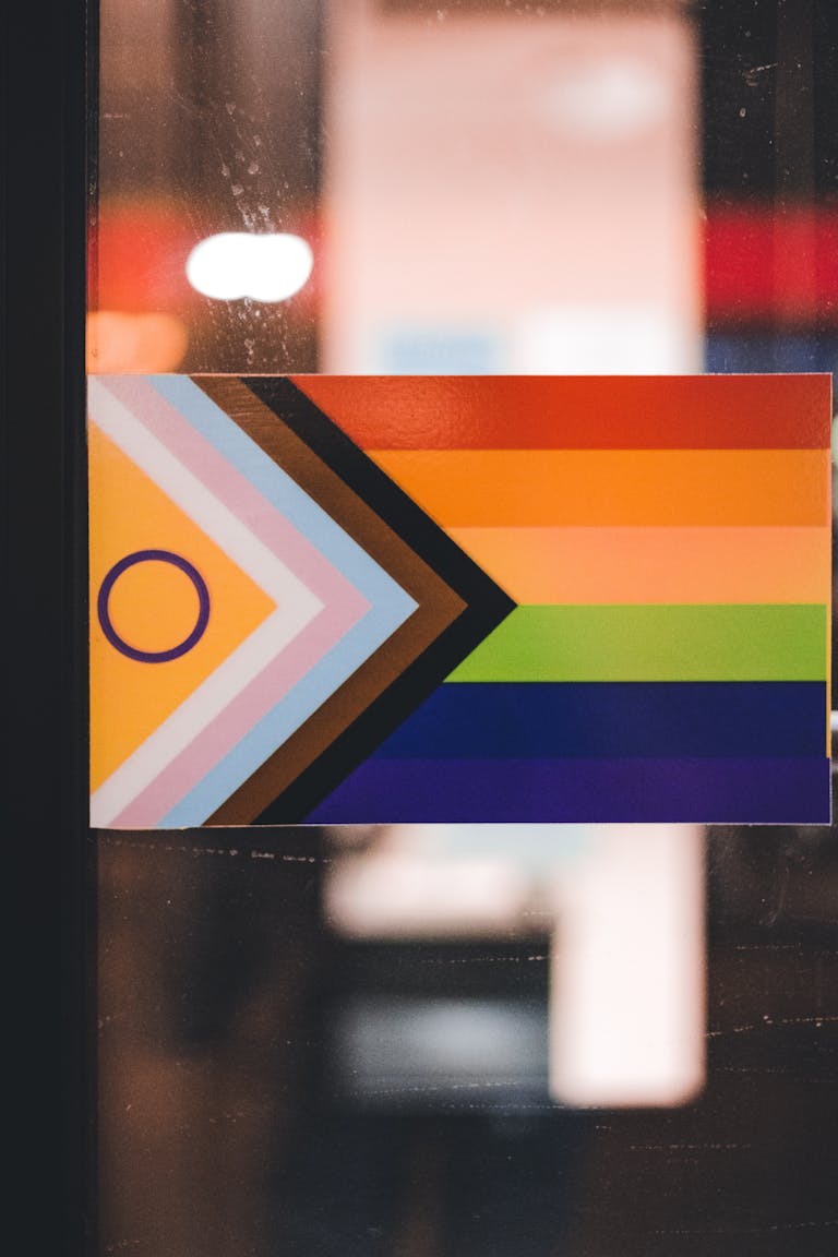 Progress Pride Flag displayed indoors, symbolizing LGBTQ+ inclusivity and diversity.