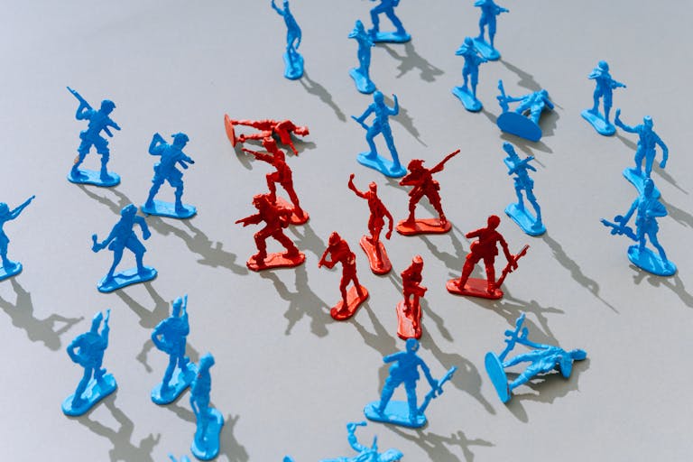 Red and blue toy soldiers on a light surface forming a strategic battle scene.