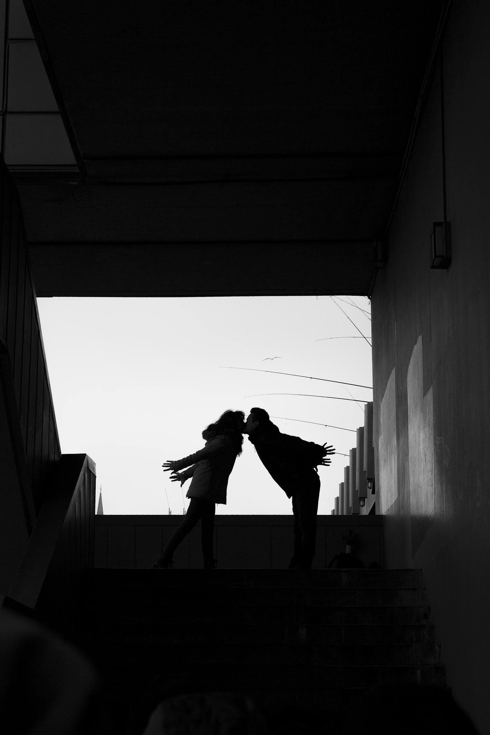Romantic silhouette of a couple kissing on a stairway at sunset in İstanbul.
