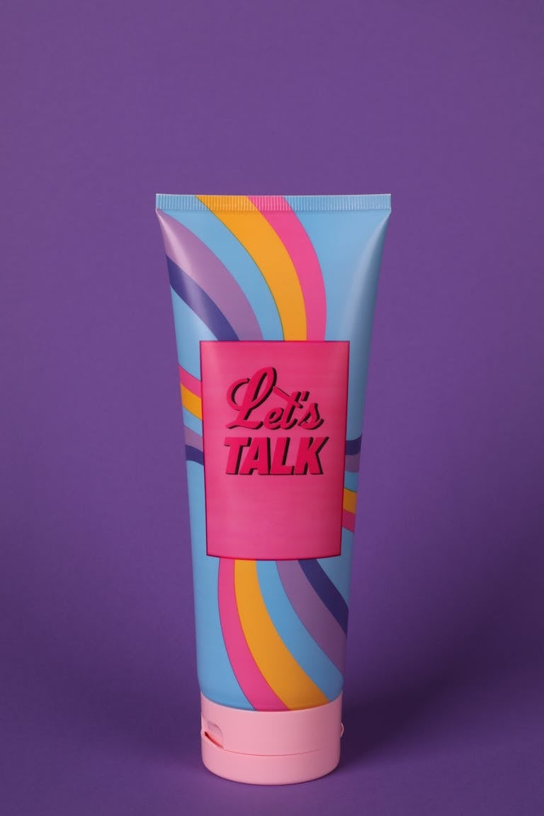 Vibrant cosmetic tube on purple background with 'Let's Talk' message.