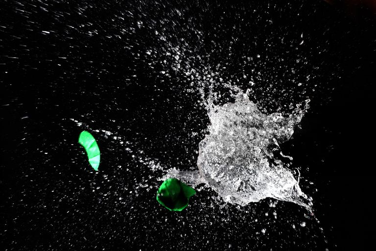 High-speed capture of a water balloon bursting, revealing dramatic splash against a dark background.